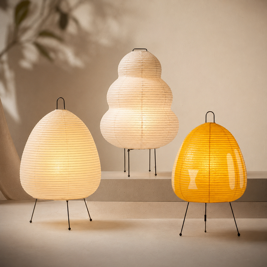 Three paper lamps with different shapes and colors on a neutral background